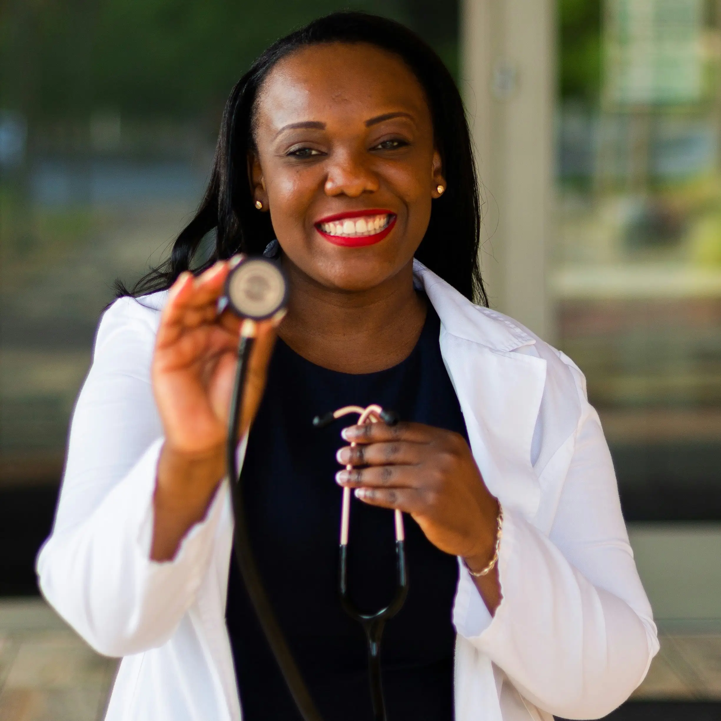 A woman holding a camera and smiling for the camera.